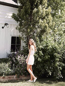 Junge Frau in weißem Playsuit im Garten