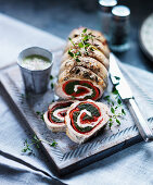 Turkey roulade filled with herbs, tomatoes and cheese, sliced