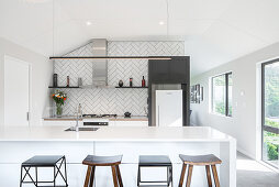 Kitchen counter with integrated sink and bar stools in open-plan kitchen