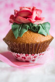 A cupcake decorated with a large sugar rose