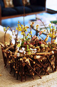 Spring flowers in DIY basket made from twigs