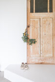 Weihnachtlicher Kranz mit Eukalyptusblättern an Holztür