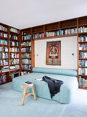 Double bed and bolster with light blue cover, framed by the bookcase in the bedroom