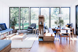 Open living room with benches, room divider shelf between the dining area and lounge