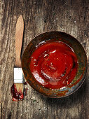 Barbecue sauce and a brush on a wooden background