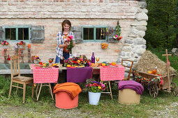 Young woman at table set for harvest festival in bright colours