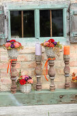 Rustikale Herbstdeko mit Blumengestecken und alten Balustern