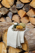 Holzscheibe mit Strickwolle und Stricknadeln vor Holzlager