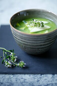 Matcha soup with green apples and cucumber in a small bowl