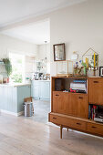 Retro sideboard in living room next to open doorway leading into kitchen