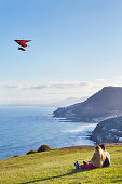 Pärchen auf Hügel am Meer mit Drachenflieger (Bald Hill, Coal Coast, Australien)