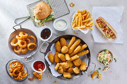 Various fast food snacks with dips, chips and coleslaw