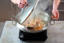 Barded saddle of pork being smoked in a hot wok