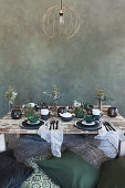 Green cushions on floor around low table with place settings