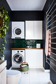 Washing machine and tumble dryer against tiled wall in utility room