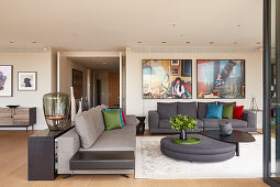 Grey sofa set, designer coffee table and large photos on wall in elegant lounge