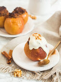 A baked apple filled with dates and walnuts served with yoghurt