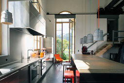 Kitchen counter and island counter with barstools in front of open window in converted loft