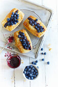 Puff pastry tartlets with jam and blueberries on a wire rack