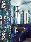Basin on vanity with dark blue tiles in the bathroom