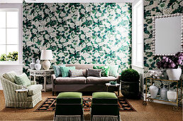 Green and white wallpaper with floral pattern and matching seating furniture in the living area