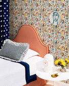 Bett mit gestreiftem Kopfteil vor Wand mit Designertapete