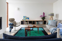 Upholstered furniture, carpet with graphic pattern and wall cabinet in the living room