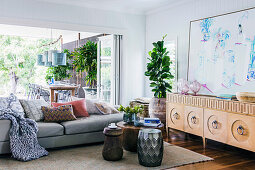 Sideboard, houseplant, coffee table and sofa in front of an open patio door in the living room