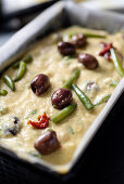 Pikanter Kuchen mit grünen Bohnen, Oliven und getrockneten Tomaten, ungebacken