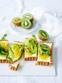 Käsekuchen mit grünen und goldenen Kiwis