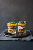 Layered salads with vegetables and melon in glasses