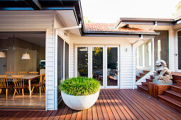 Terrace with dark wooden floor at the house with an open door to the dining room