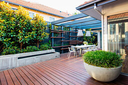 Moderner Hinterhof mit Terrasse und Sitzplatz unter der Pergola