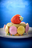 A children's cake with macarons and a strawberry