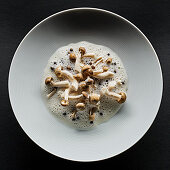 Enoki mushrooms on a plate with foam