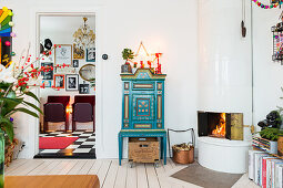 Christmas arrangement on turquoise cabinet next to tiled stove