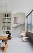 Cat on wooden table in dining area with concrete floor