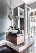 Countertop basin on an elegant washstand, above it an oriental pendant lamp