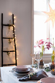 Festively set table and ladder decorated with fairy lights