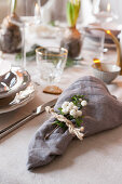 Sprig of berries and napkin tied with string on set dining table