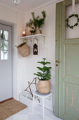 Green wooden door in festively decorated hallway