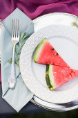 Serviette mit Gabel neben Teller mit Wassermelonenstücken