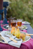 Pears and tea on set table in garden