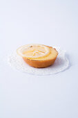 A mini tartlet with lemon cream against a white background