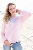 Blonde Frau in lila T-Shirt und rosa Pullover