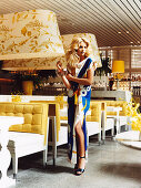 Junge Frau in bedrucktem, sommerlichem Maxikleid in einem Restaurant