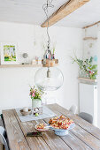 Glass pendant lamp above rustic wooden table in dining room