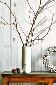 Bare branches in stone vase and pine cones as Christmas decorations