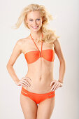 Junge blonde Frau in orangefarbenem Bikini