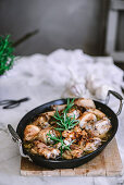 Pan with tasty roasted chicken with rosemary on table.